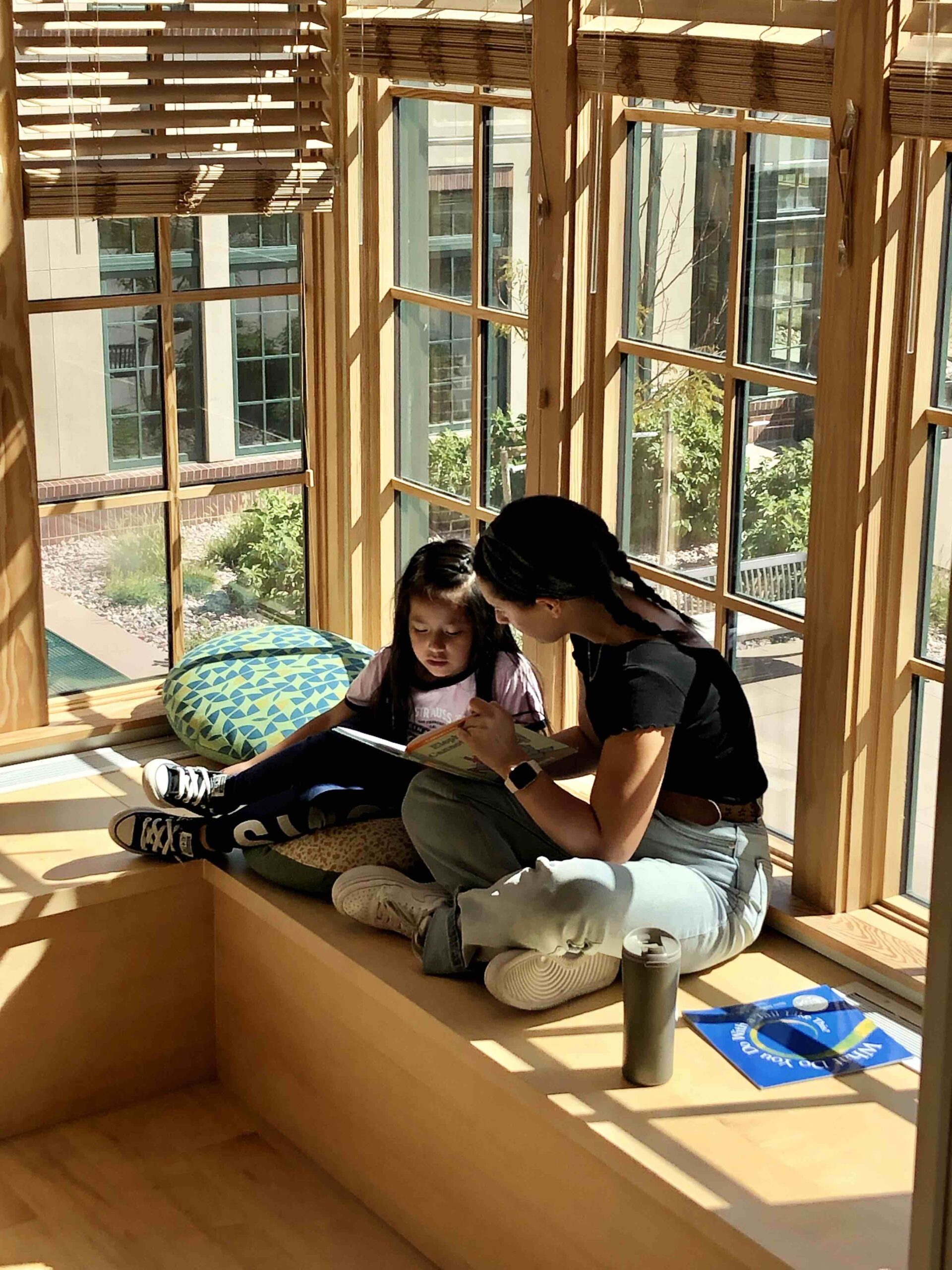 Personalized Learning Portfolios Instructor sitting with student reading